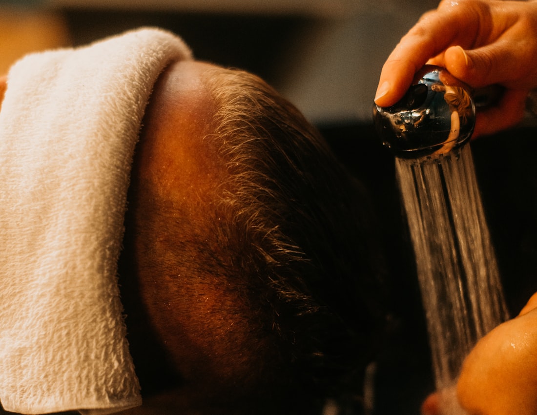 Cabello masculino siendo lavado e hidratado
